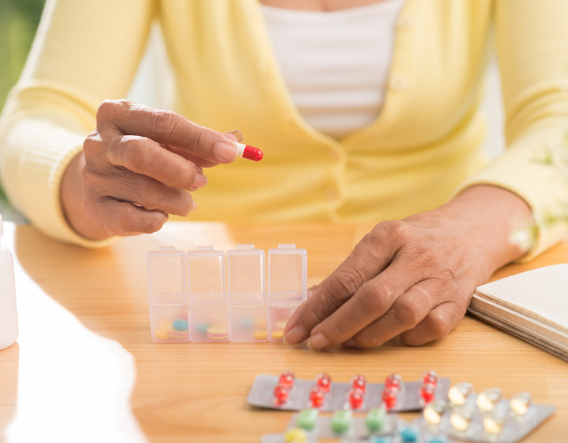 Woman-organizing-medication-in-plastic-container